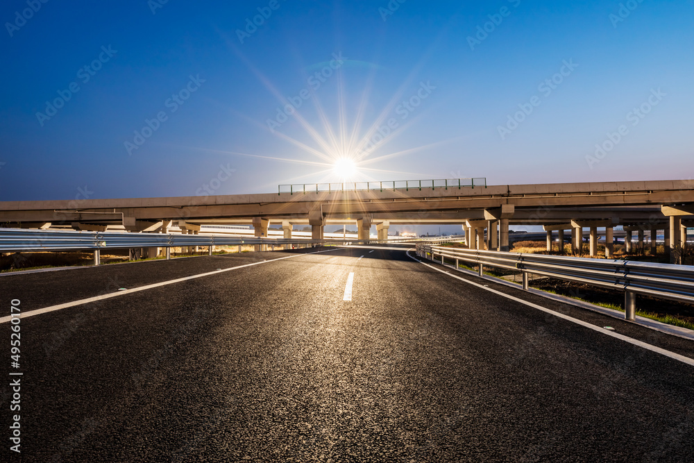 Asphalt highway and bridge with street lights at night