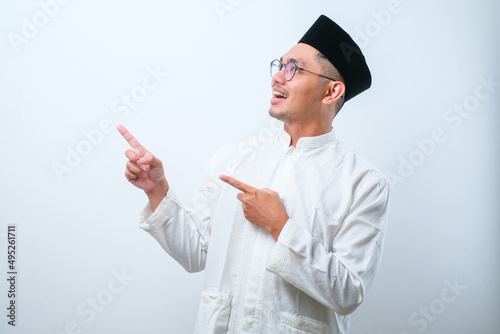 Asian muslim mas pointing something on his side with his both hand photo