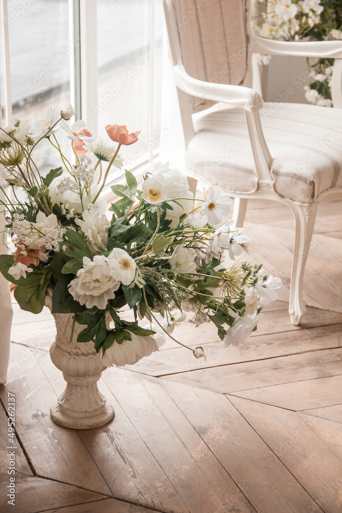 spring flowers in vase near white armchair at the window background in a classic interior. lifestyle concept, free space