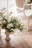 spring flowers in vase near white armchair at the window background in a classic interior. lifestyle concept, free space