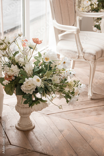 spring flowers in vase near white armchair at the window background in a classic interior. lifestyle concept  free space