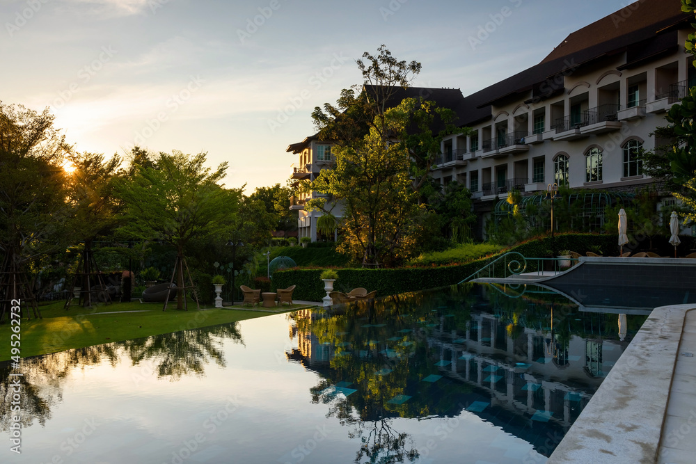 Luxury hotel swimming pool and garden at sunrise