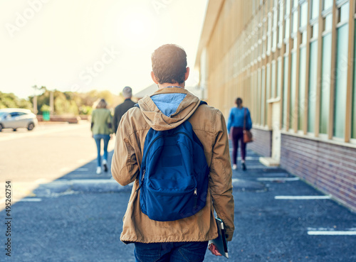 On my way to class. Shot of a college student between classes on campus grounds.