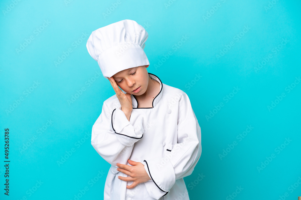 Little chef boy isolated on blue background with headache
