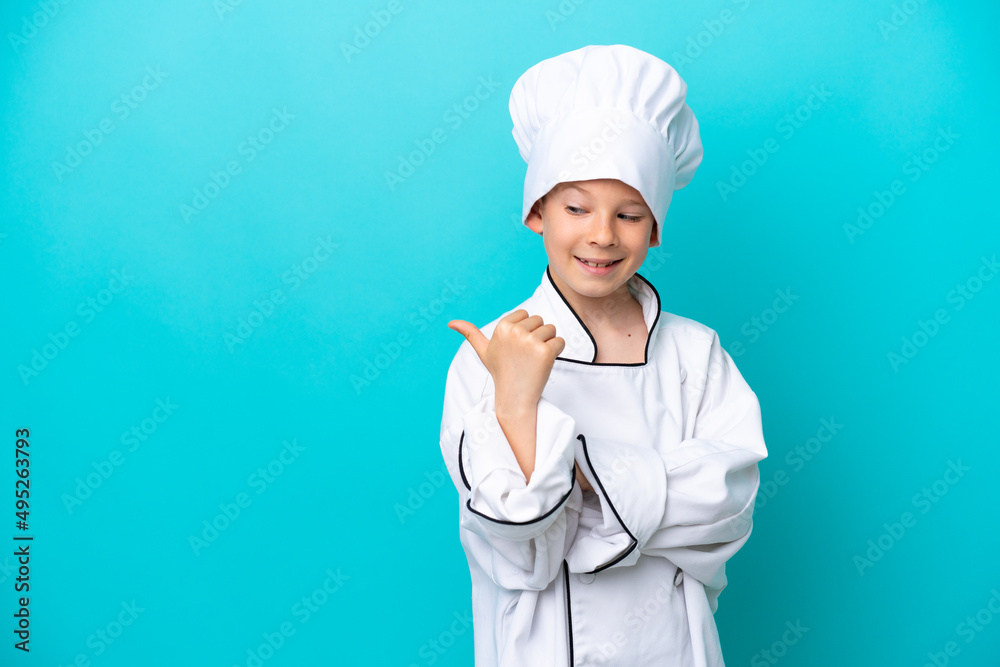 Little chef boy isolated on blue background pointing to the side to present a product Little chef boy isolated on blue background pointing to the side to present a product