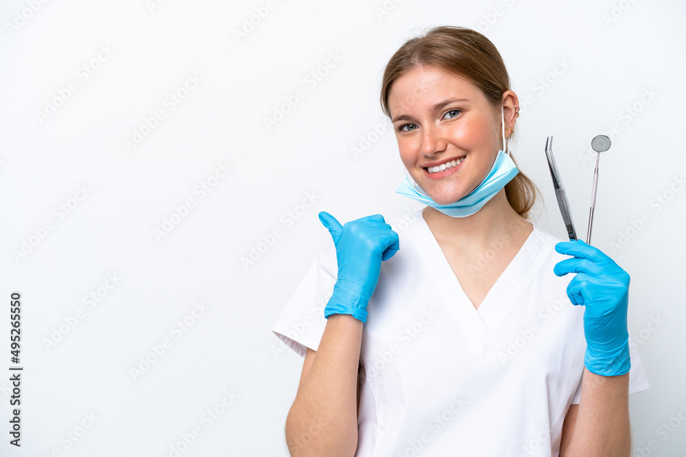 Dentist caucasian woman holding tools isolated on white background pointing to the side to present a product Dentist caucasian woman holding tools isolated on white background pointing to the side to present a product