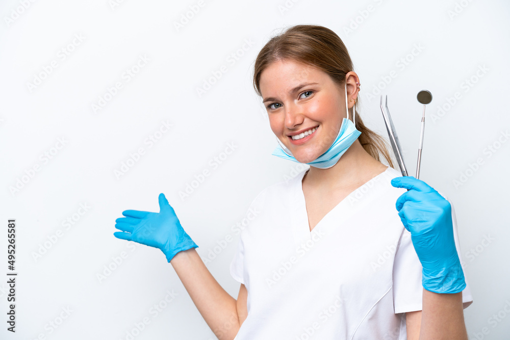 Dentist caucasian woman holding tools isolated on white background extending hands to the side for inviting to come Dentist caucasian woman holding tools isolated on white background extending hands to the side for inviting to come