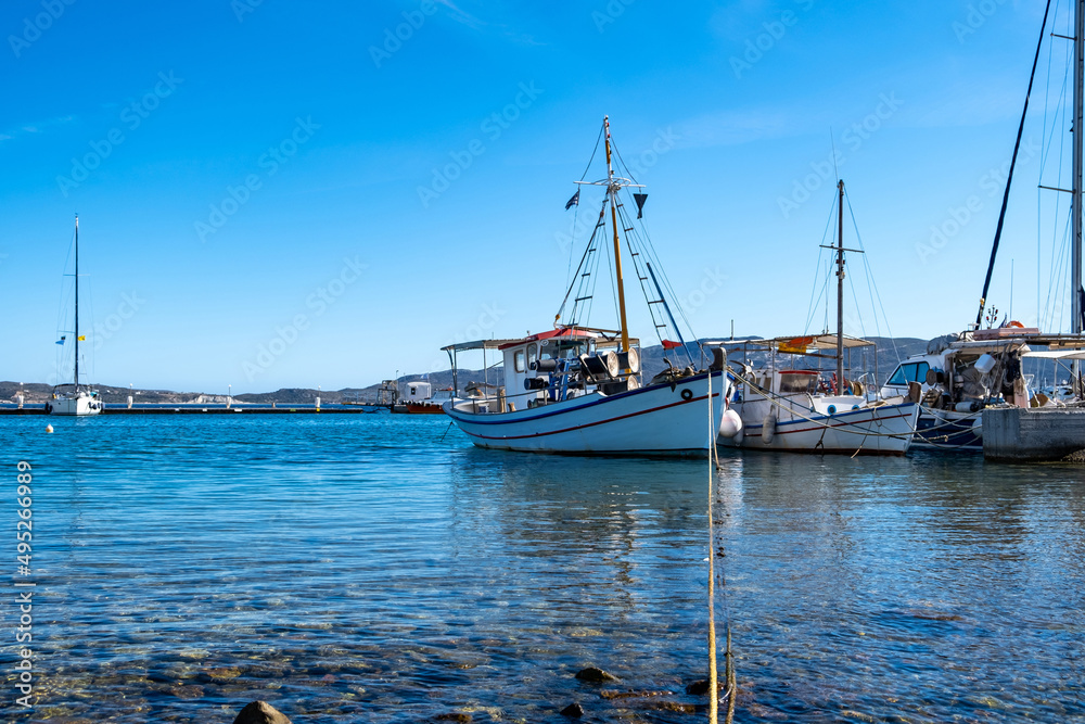 Fishing boat moored at Koufonisi Greek island port dock. Cyclades, Aegean sea, blue sky background.
