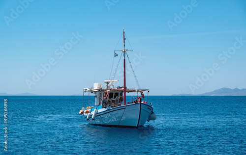 Wooden fishing boat moored in Aegean sea, blue sky background. Koufonisi Greek island, Cyclades.