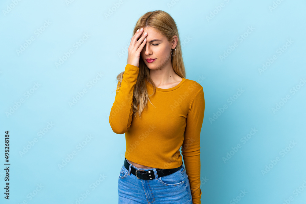 Young Uruguayan blonde woman over isolated blue background with headache