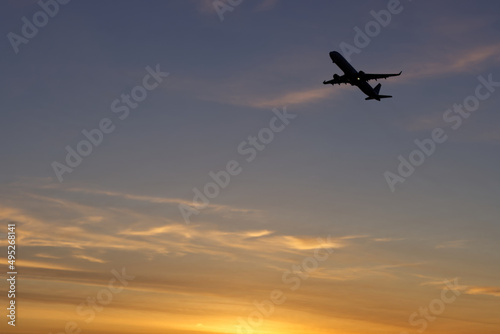 Airplane flying in the sky during sunset. Holidays and business travel concept.