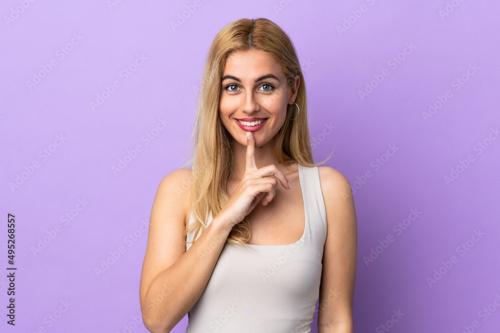 Young Uruguayan blonde woman over isolated background showing a sign of silence gesture putting finger in mouth Young Uruguayan blonde woman over isolated background showing a sign of silence gesture putting finger in mouth