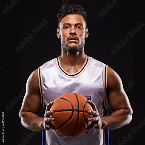 Who goes first. Studio shot of a basketball player against a black background. © Duncan M/peopleimages.com
