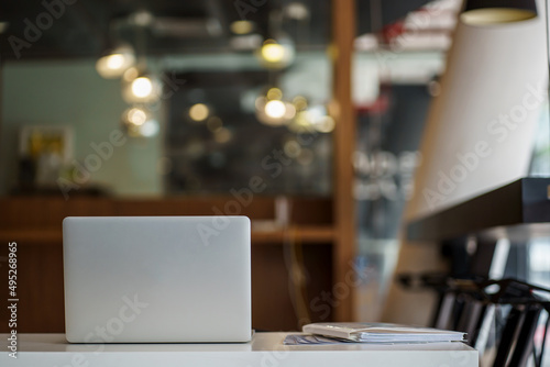 Back view of laptop on table in modern business office with blurry background.