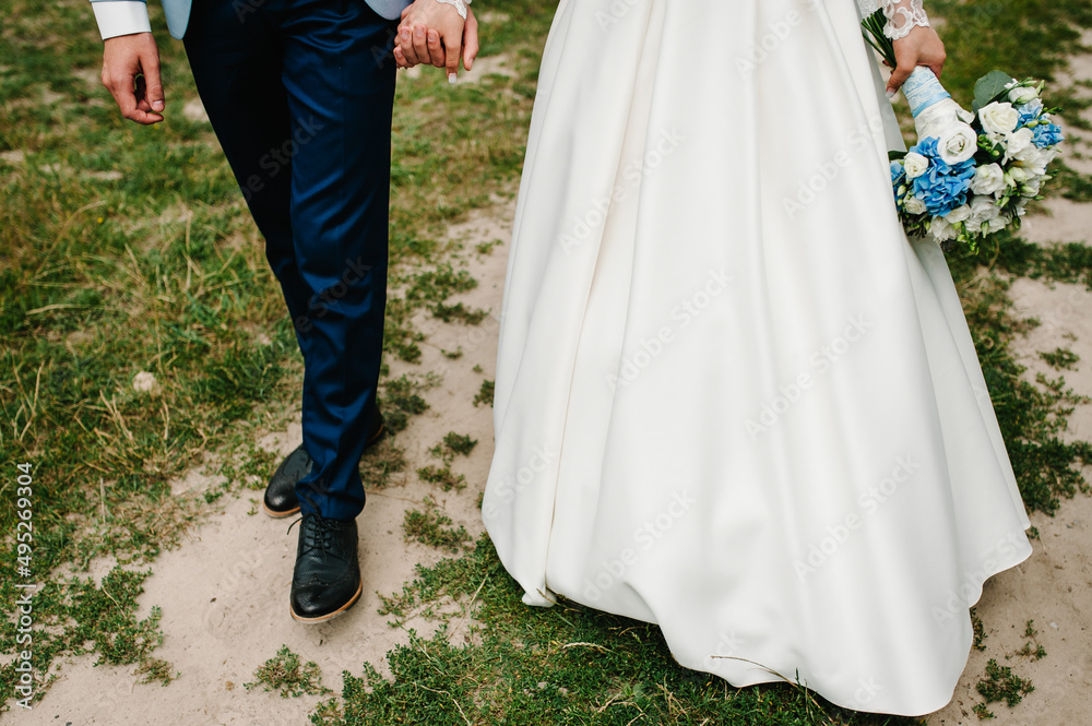 Wedding couple walking in nature. Bride in a dress and groom go in a green forest. Down view. Wedding couple walking in nature. Bride in a dress and groom go in a green forest. Down view.