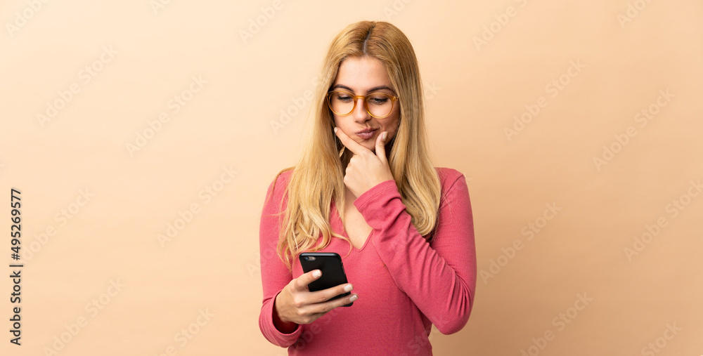 Young Uruguayan blonde woman over isolated background thinking and sending a message Young Uruguayan blonde woman over isolated background thinking and sending a message