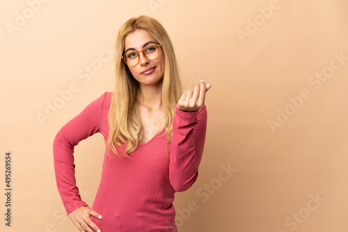 Young Uruguayan blonde woman over isolated background making Italian gesture