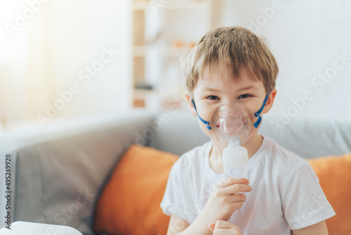 Smiling little boy wearing nebulizer mask close-up. photo