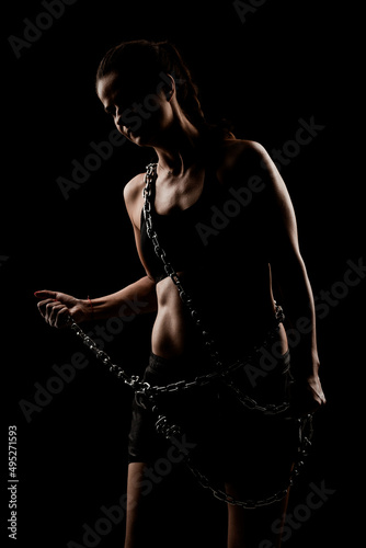 Strong fit girl with metal chain. Pulling and posing against black background.. © Nikola Spasenoski
