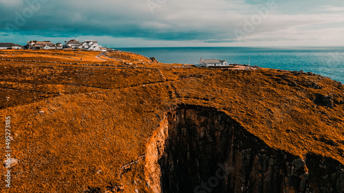 Billede på lærred Building on the background of the ocean on top of a cliff Aerial view