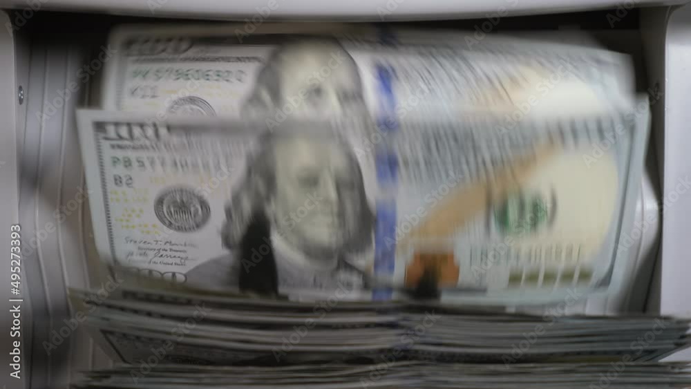 Money counting machine counts 100 dollar bills. Close up shot