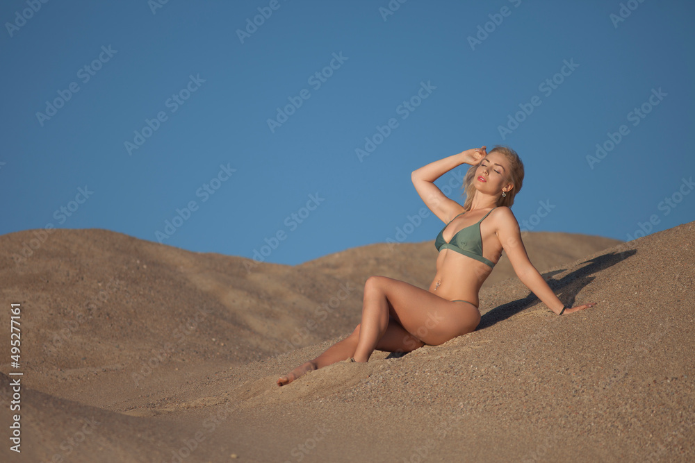 sports woman in a swimsuit on the sand
