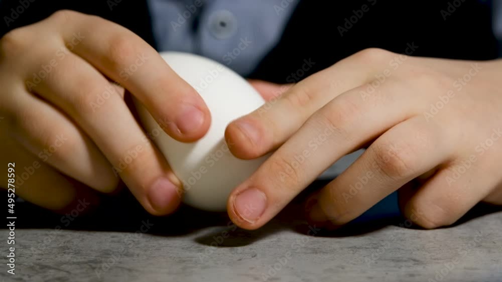 A child breaks a boiled egg A child breaks a boiled egg