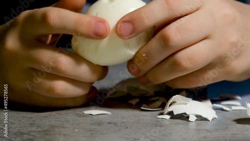 A child cleanses a boiled egg from the shell