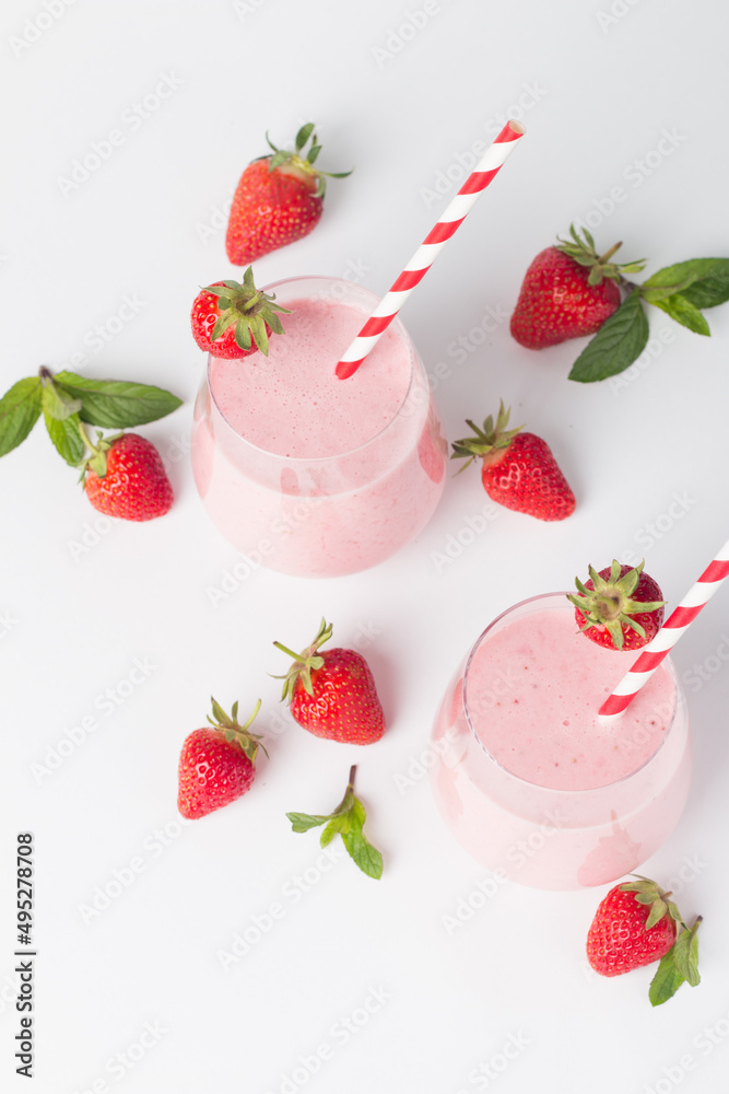 A glass of fresh strawberry smoothie on a white background. Summer drink shake, milkshake and refreshment organic concept. A glass of fresh strawberry smoothie on a white background. Summer drink shake, milkshake and refreshment organic concept.