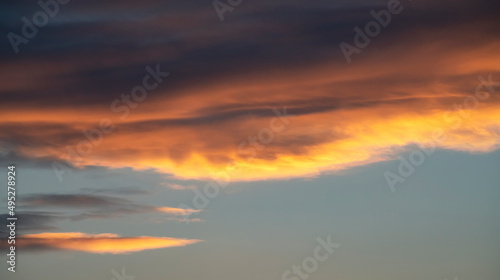 Beautiful dark golden sunset sky with clouds. Sky background. © Inga Av