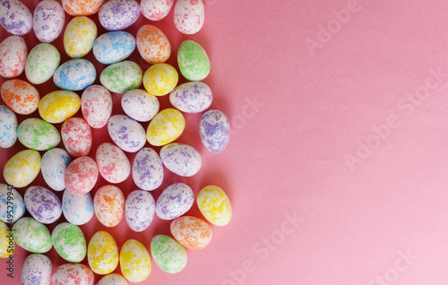 Easter eggs are multicolored on a pink background. Holiday. Eggs are small from foam plastic. Copy space. View from above. Easter. Toy.