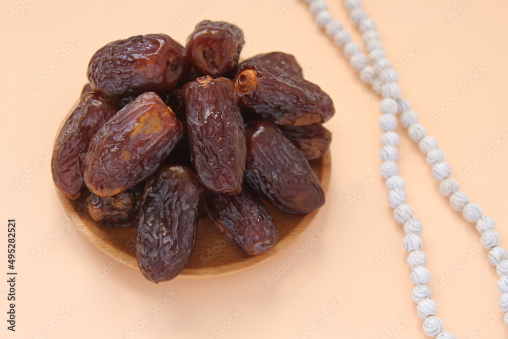 Fresh date fruits and white prayer beads, ramadhan concept idea. Sitting view. Vibrant color date fruit prepared for iftar. Fresh date fruits and white prayer beads, ramadhan concept idea. Sitting view. Vibrant color date fruit prepared for iftar.