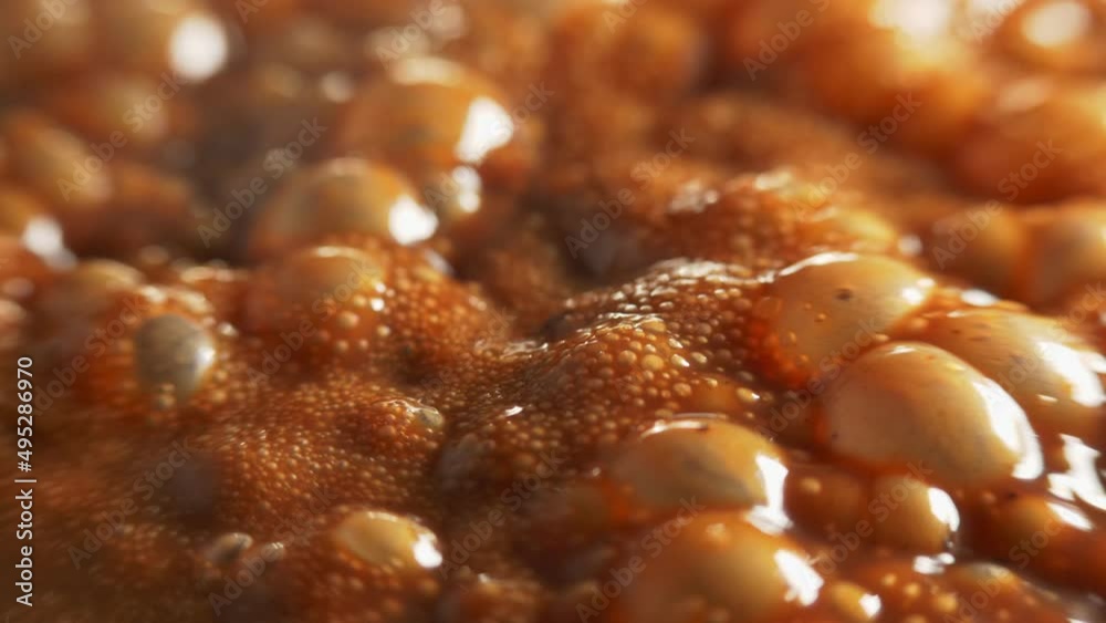 Macro shot of bubbles in boiling thick brown liquid, shallow depth of field. Macro shot of bubbles in boiling thick brown liquid, shallow depth of field.