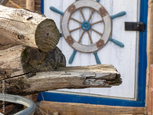 Holzstapel vor einer Holztür mit Ruderrad photo