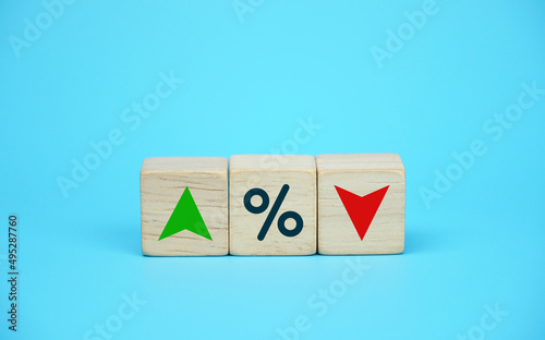Fototapeta Naklejka Na Ścianę i Meble -  Interest rate financial and mortgage rates concept. Wooden cube block with icon percentage, symbol arrow up and down. blue background.	