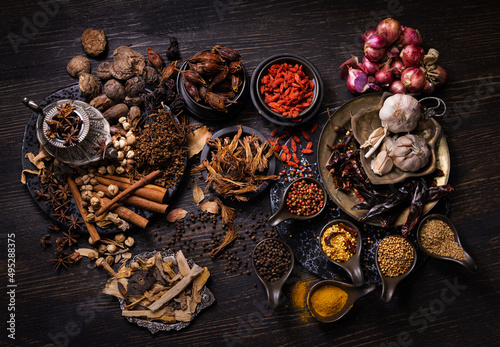Thai native food, spices herbs, and various ingredients taken from top view angle.  Group of hot and spicy dry vegetables, nuts, and grains for making Asian food on wooden background. Dark tone photo