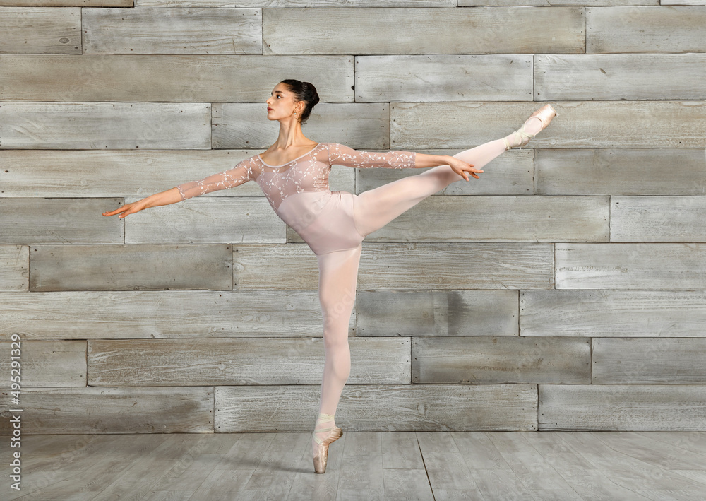 Slim ballerina performing Arabesque pose - obrazy, fototapety, plakaty 