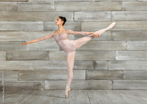 Fototapeta Naklejka Na Ścianę i Meble -  Slim ballerina performing Arabesque pose