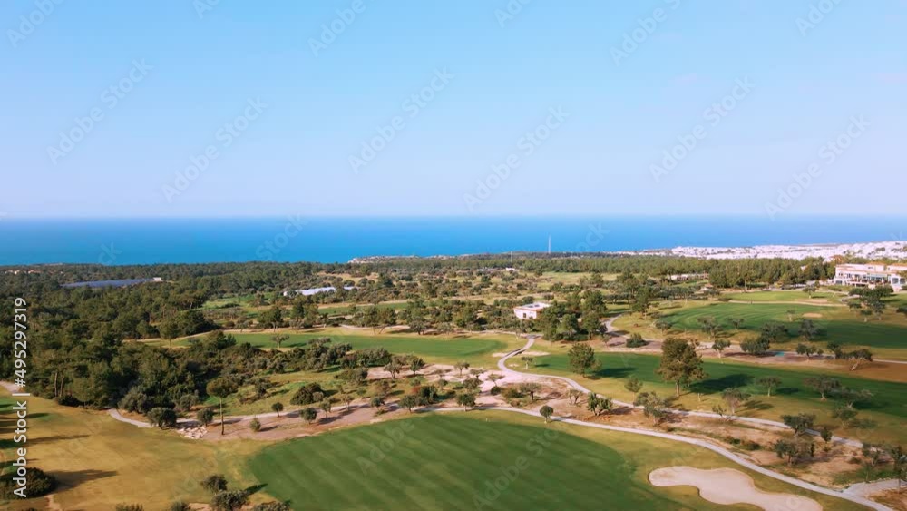 Aerial view of Golf Course with putting green grass and trees on golf field Fairway and putting green top view Amazing bird eye view over Golf courses in summer sunny day in Cyprus Aerial view of Golf Course with putting green grass and trees on golf field Fairway and putting green top view Amazing bird eye view over Golf courses in summer sunny day in Cyprus