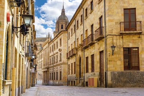 Medieval street with the dome of the cathedral in the background in the city of Salamanca.