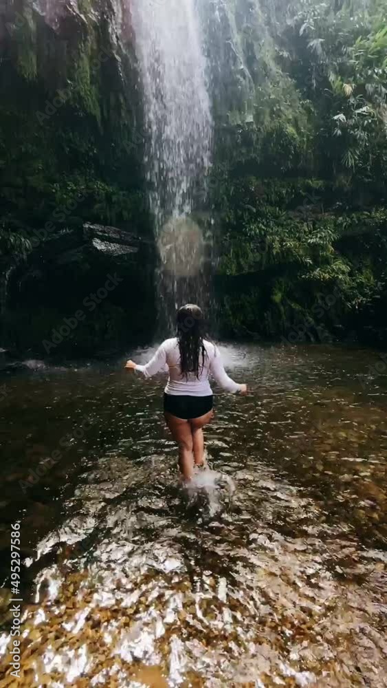 woman walkin to waterfall in the forest woman walkin to waterfall in the forest