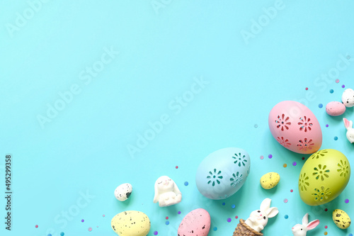 Easter composition. Easter eggs and easter bunny on pastel blue background. Minimal concept of Easter. Flat lay  top view  copy space.