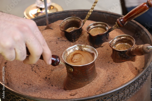 Turkish coffee cooked in hot sand in copper coffee pots prepared for tourists in Taksim, the most touristic district of Istanbul.