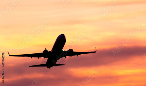 Passenger plane at the airport in the sunset. Summer travel by plane. Real photo. Beautiful natural sunlight.