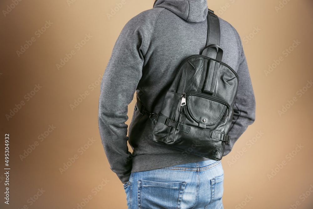 man wearing casual clothes with leather backpack studio photo shot on brown background. man wearing casual clothes with leather backpack studio photo shot on brown background.