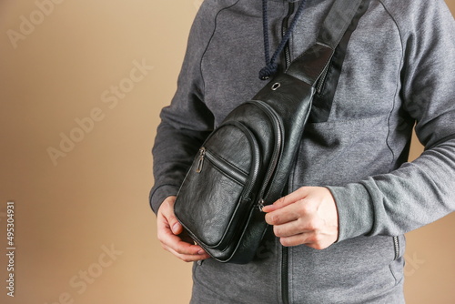 men's leather sling bag is on person close up photo