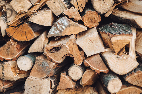 Fotografija Firewood background - chopped firewood on a stack