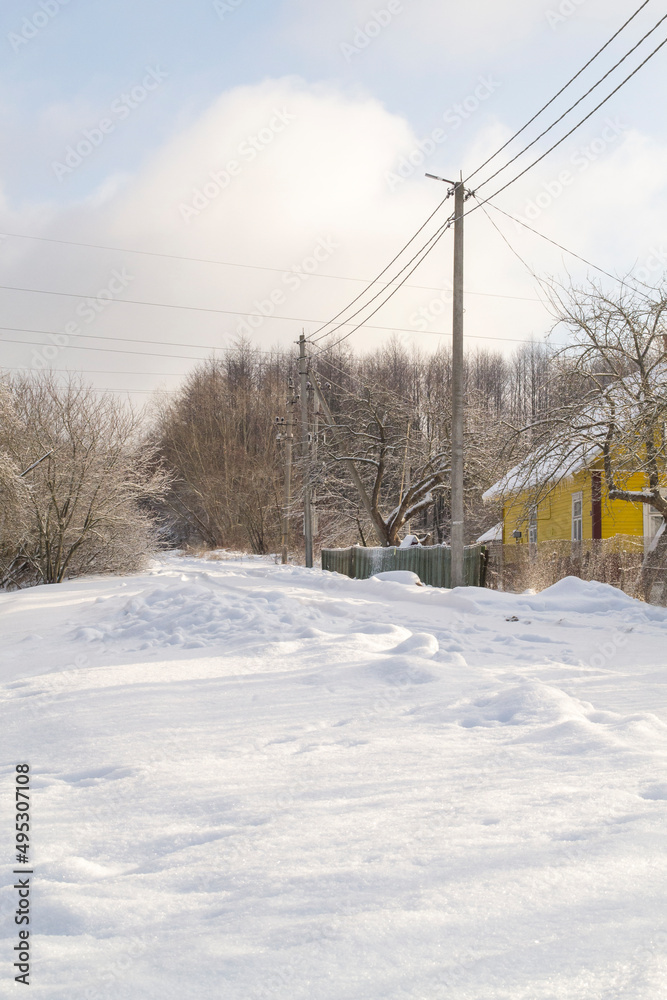 Snow-covered village streets in winter. Frosty morning. Vertical image