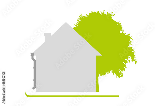 House on a green lawn next to a tree. A flat one-color house, simple in shape. Sunny day. Isolated