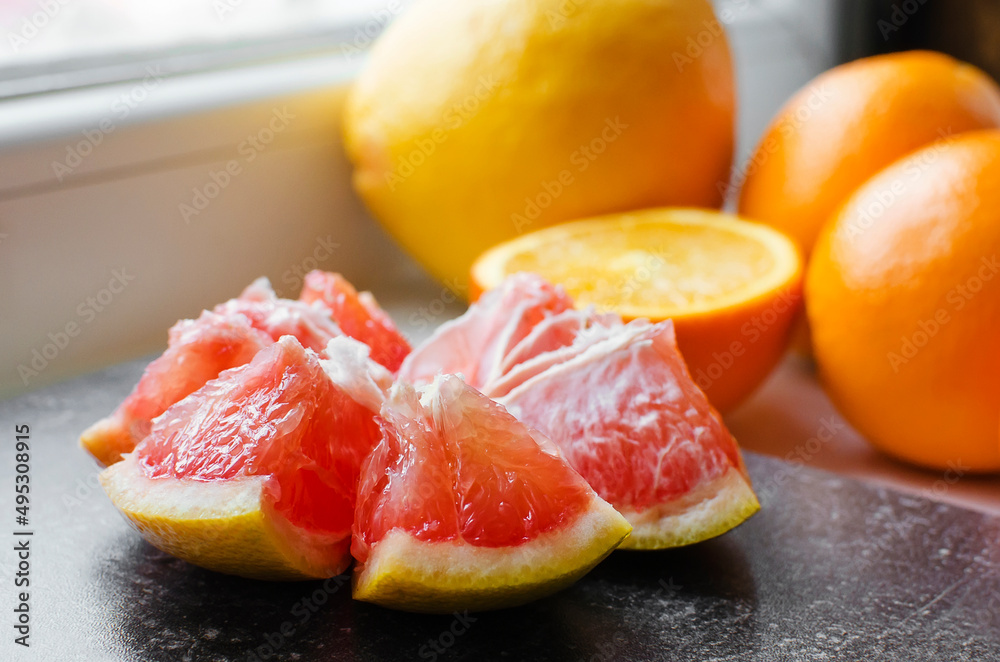 Citrus fruits: oranges, grapefruit. Peeled grapefruit on a vintage board. Close-up, selective focus. Citrus fruits: oranges, grapefruit. Peeled grapefruit on a vintage board. Close-up, selective focus.